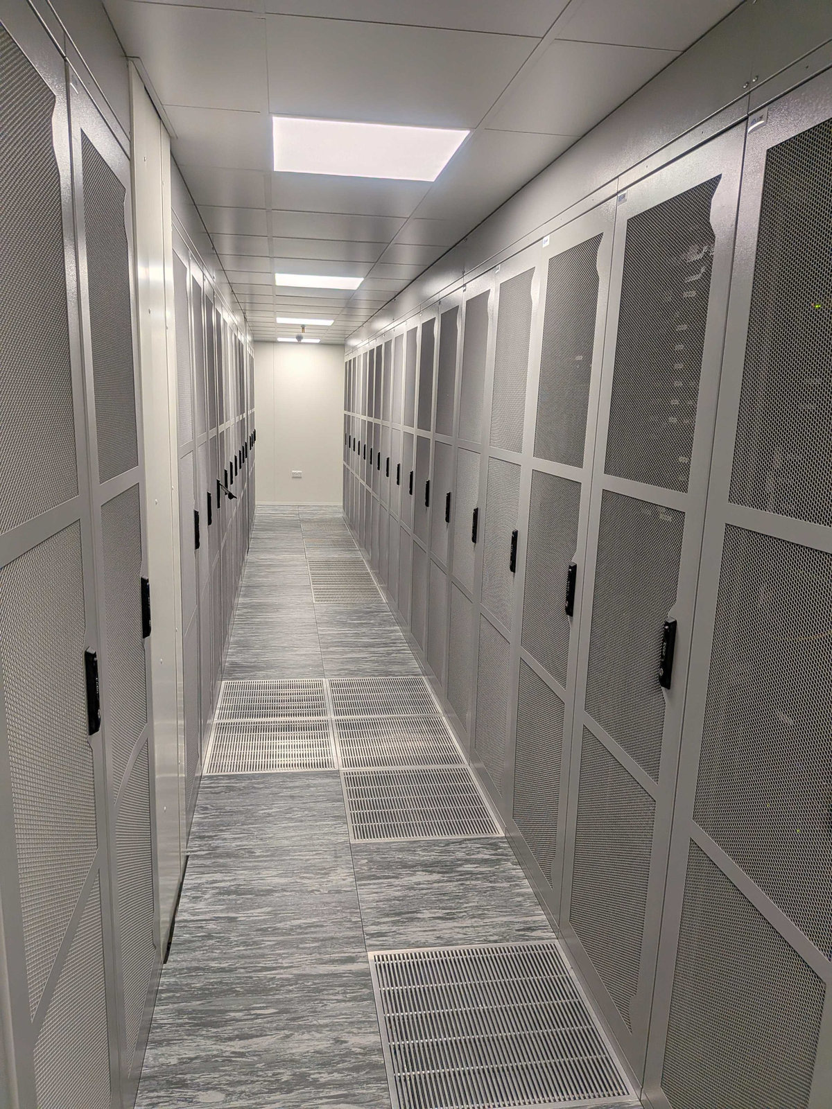 A long aisle of white cabinets in the new managed data centre.