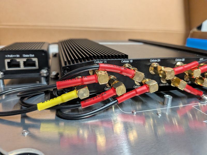 Close-up of gold SMA connectors and colour-coded cabling on a Peplink MAX BR2 Pro.